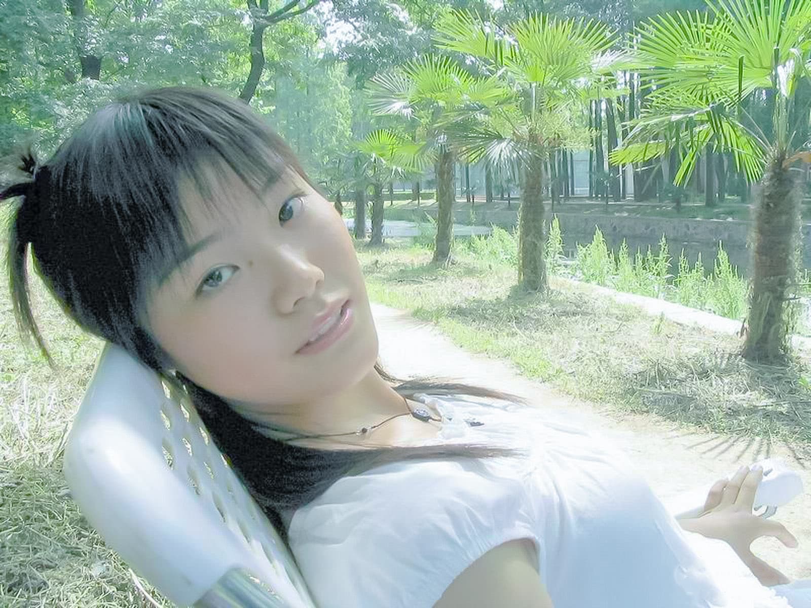 Ground-level shot of stocking hem above the ankle, toes peeking from a sandal, soft leaves and sunlit path in the background